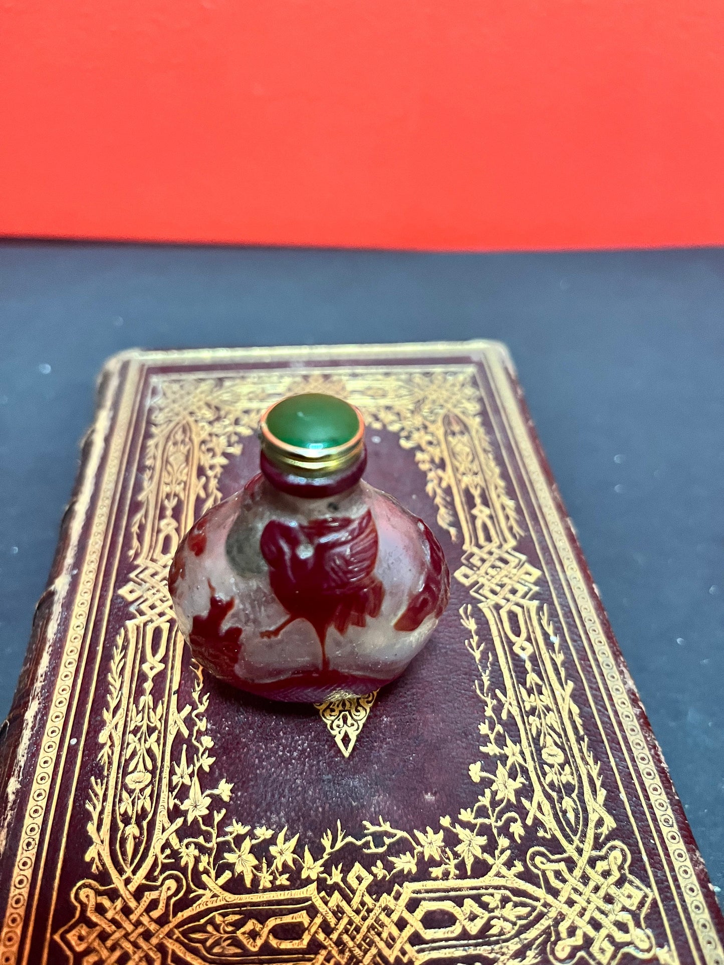 An antique 2 inch high antique Chinese Peking glass snuff bottle with enamel stopper