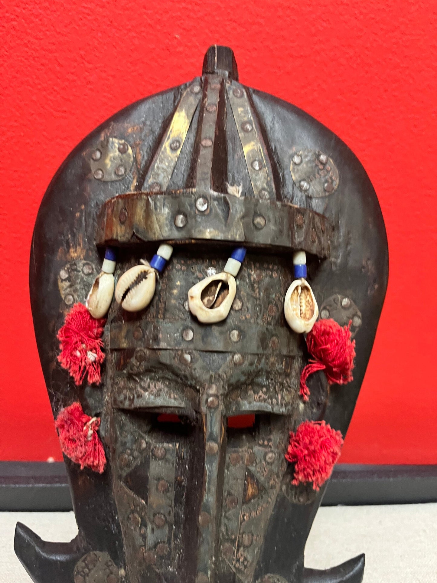 A 10 inch African mask with metal and puka shells   very decorative and old