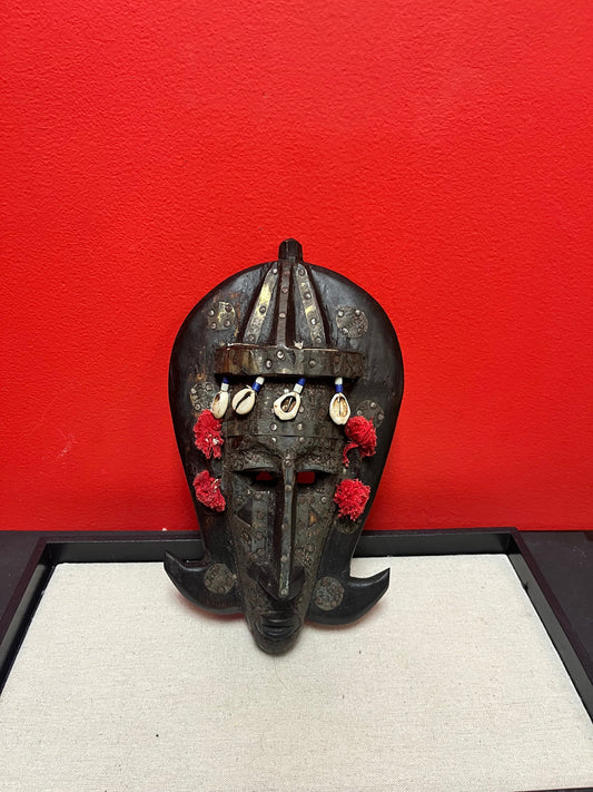 A 10 inch African mask with metal and puka shells   very decorative and old