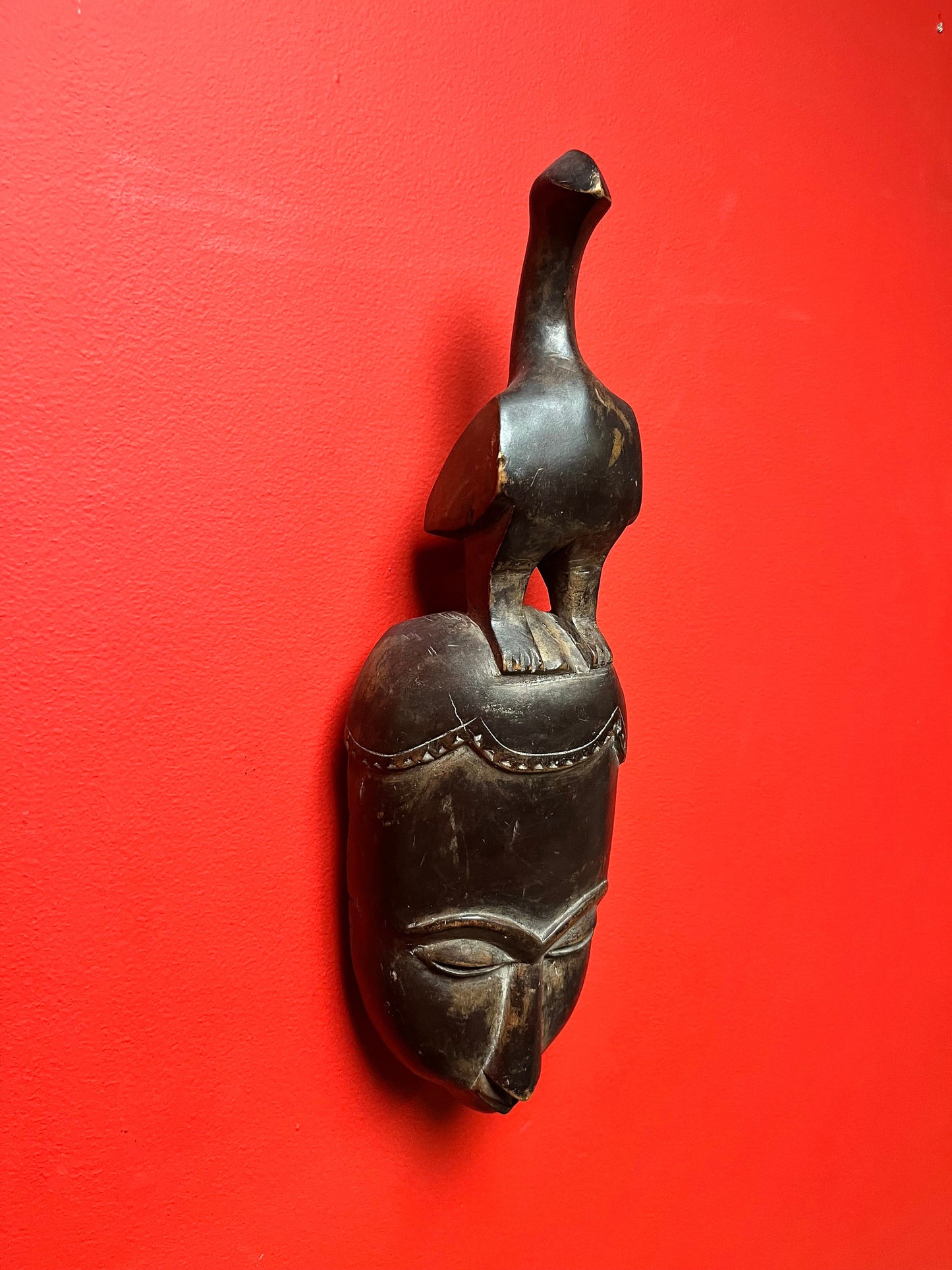 Studying antique ceremonial western African 11 inch tall bird mask   great patina and condition