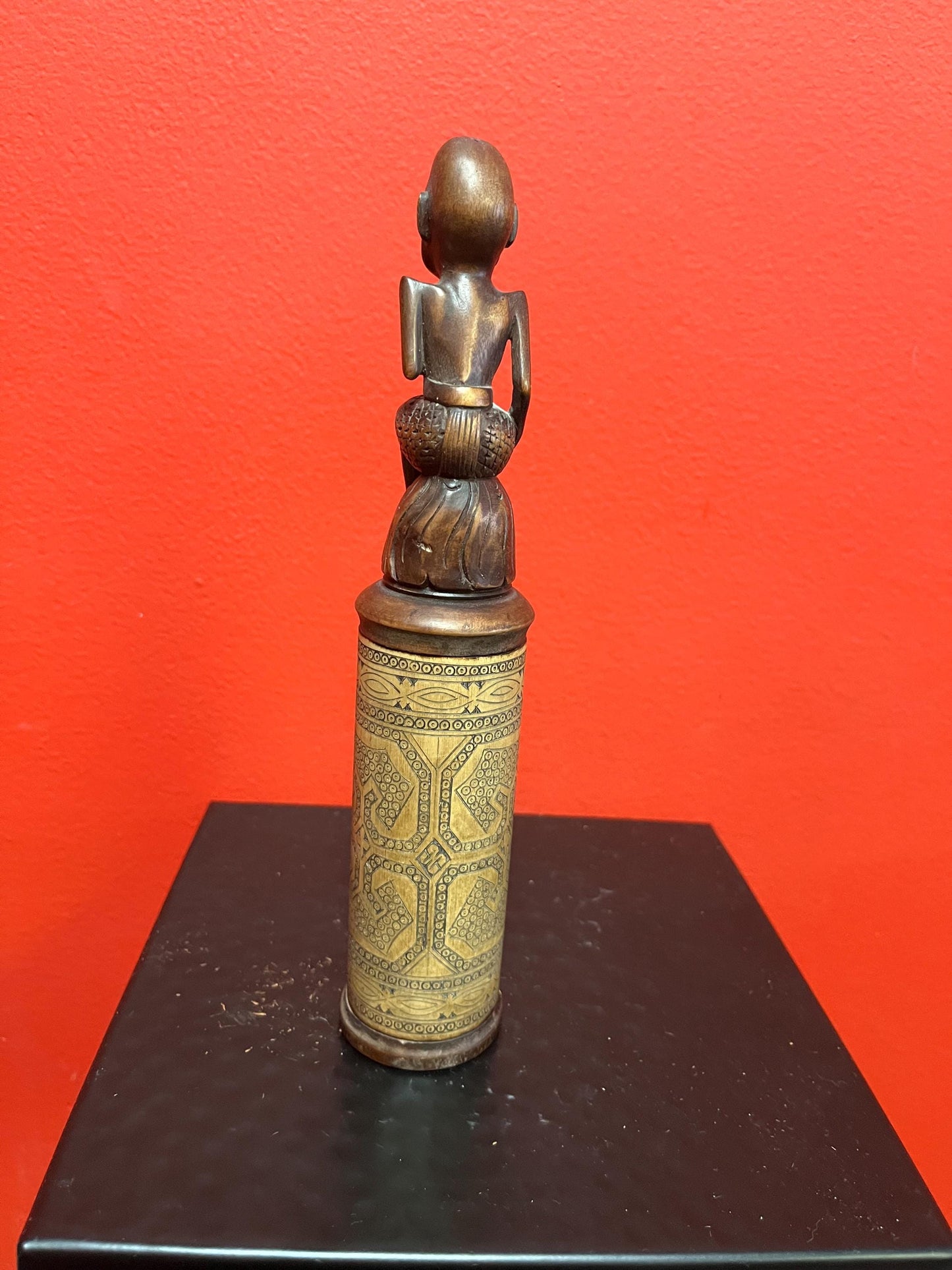 An 8 inch tall  African wooden canister with beautiful carved man on top  highly detailed and wonderful imagery  great value