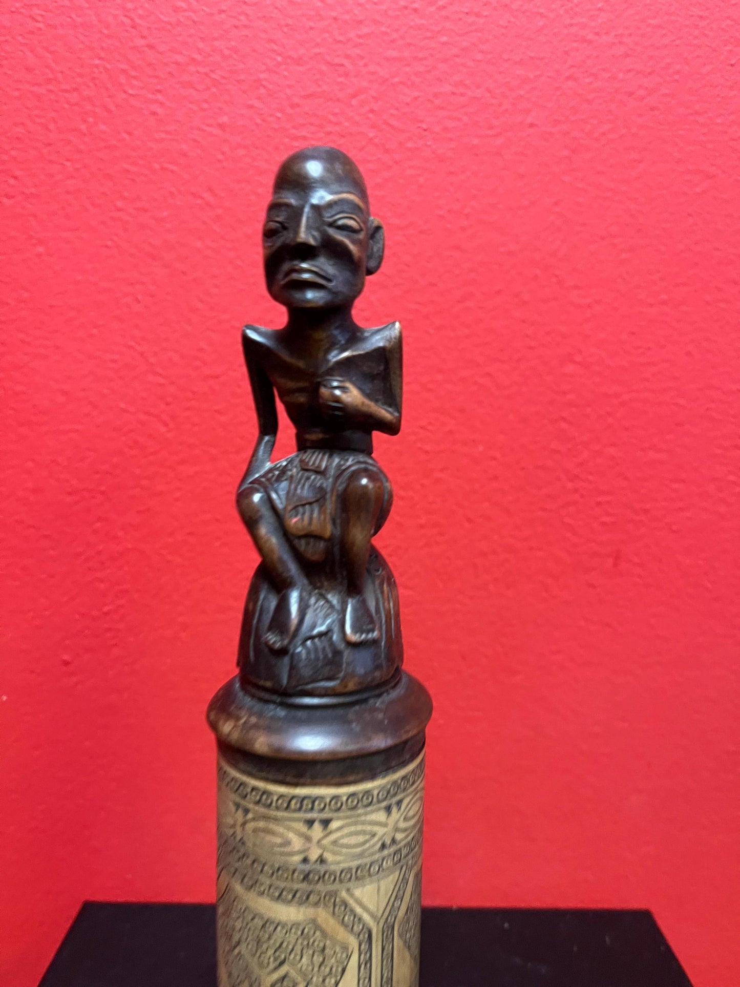 An 8 inch tall  African wooden canister with beautiful carved man on top  highly detailed and wonderful imagery  great value