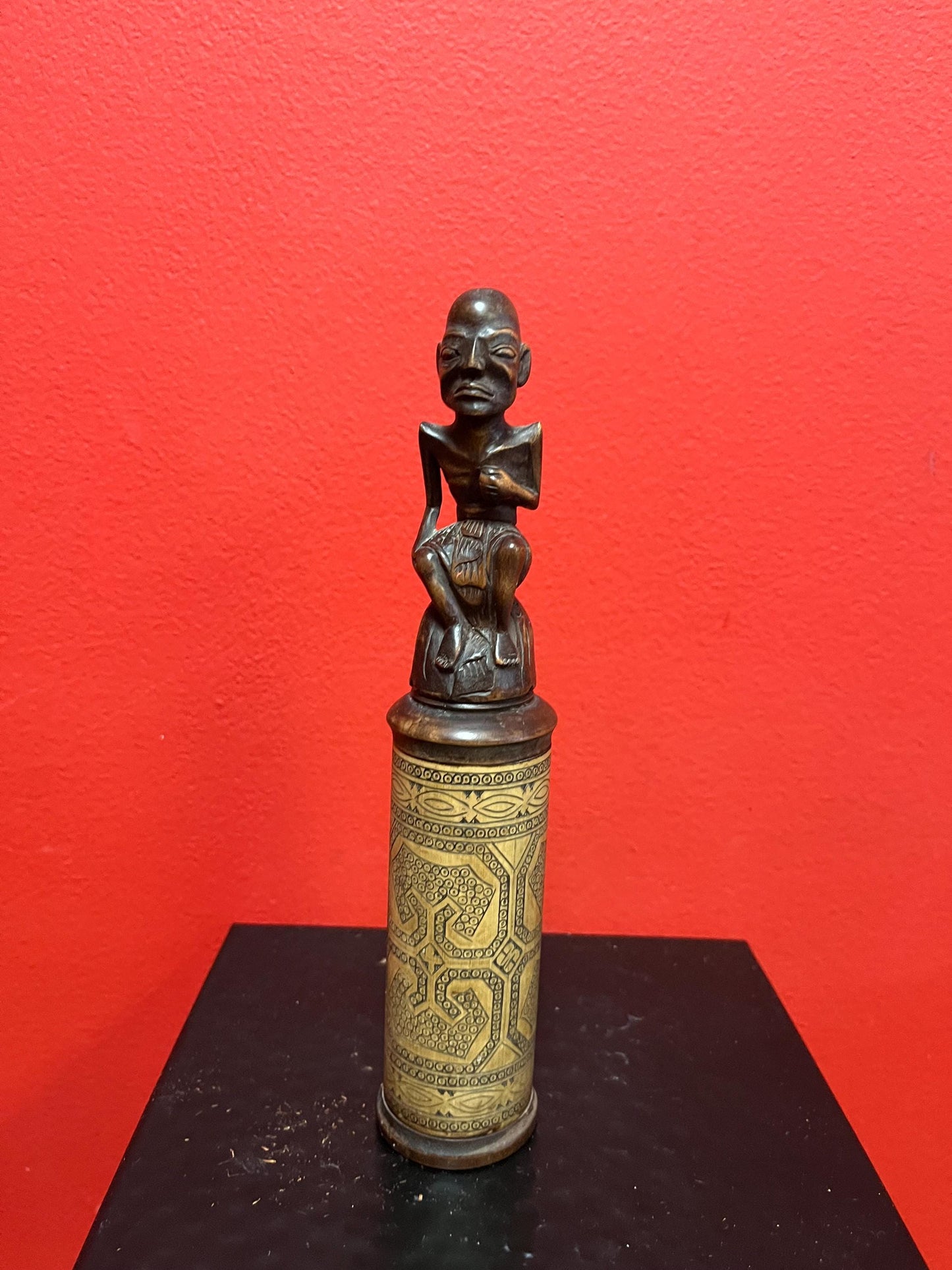 An 8 inch tall  African wooden canister with beautiful carved man on top  highly detailed and wonderful imagery  great value