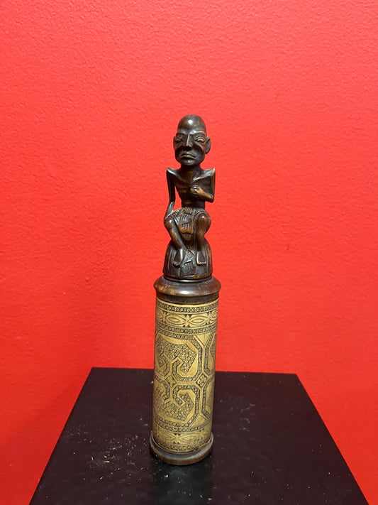 An 8 inch tall  African wooden canister with beautiful carved man on top  highly detailed and wonderful imagery  great value