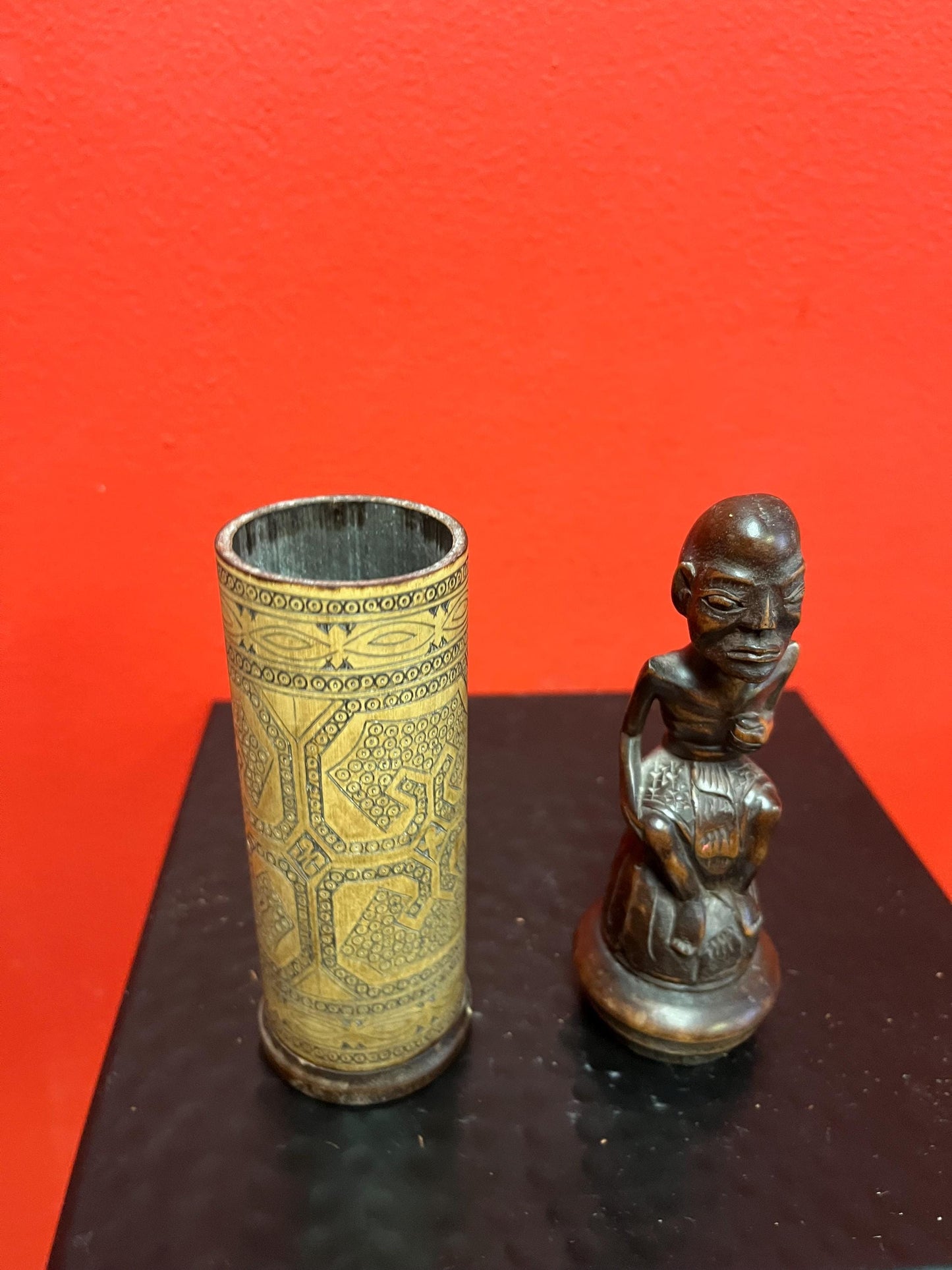 An 8 inch tall  African wooden canister with beautiful carved man on top  highly detailed and wonderful imagery  great value